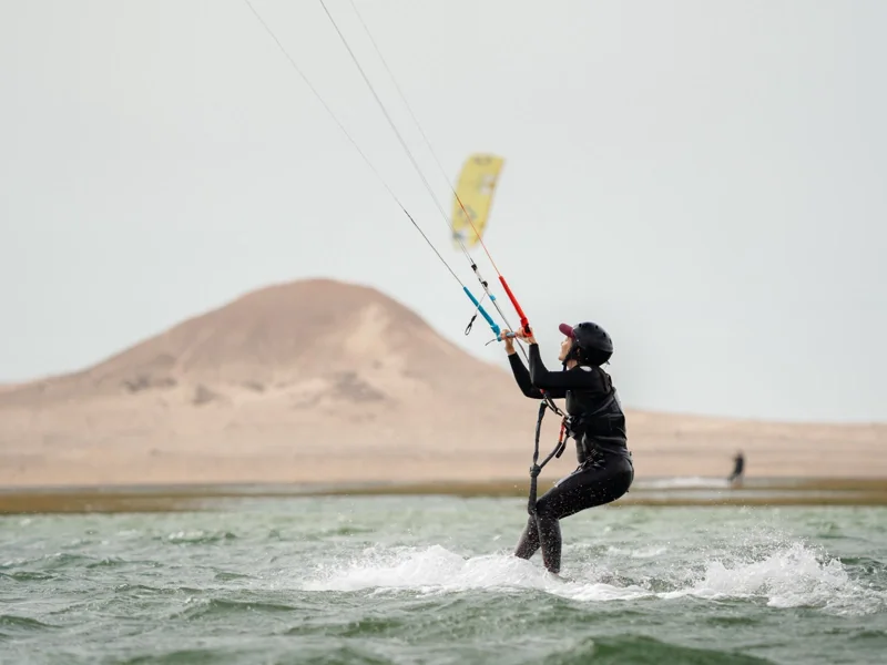 Kitesurfeuse en navigation à Secret Spot, devant les dunes de Dakhla